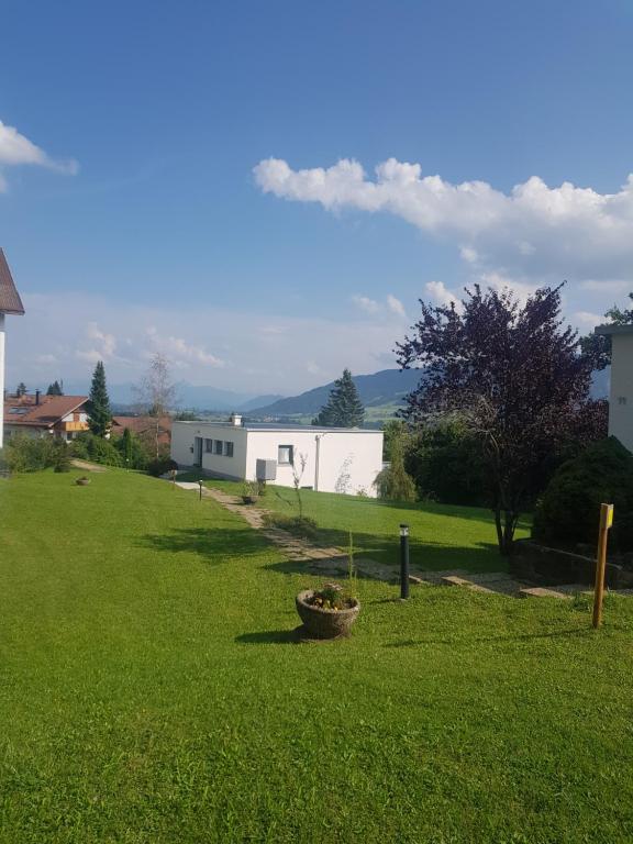 Im Alpennest في Niederdorla: ساحة خضراء مع مبنى في الخلفية