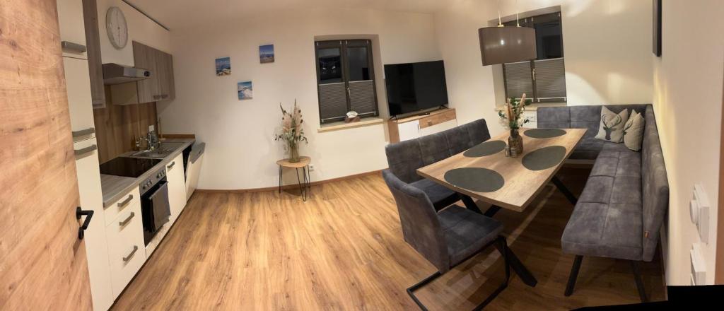 a kitchen and living room with a table and a couch at Appartement Steinbergrose in Leogang