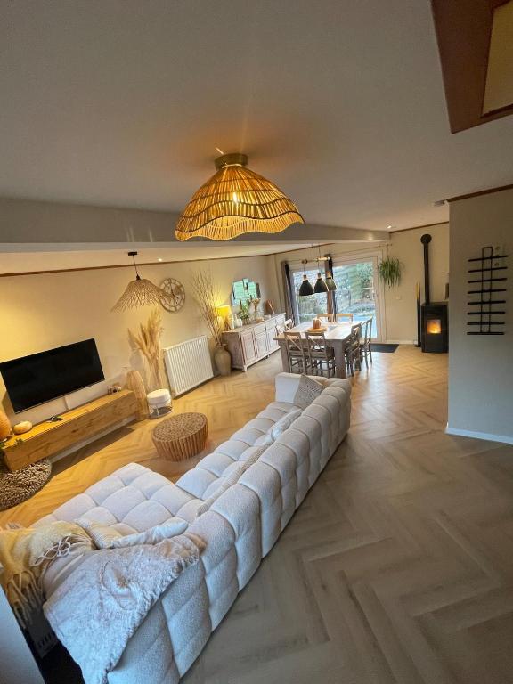 a living room with a large white couch and a table at Charmante maison rénovée in Fernelmont