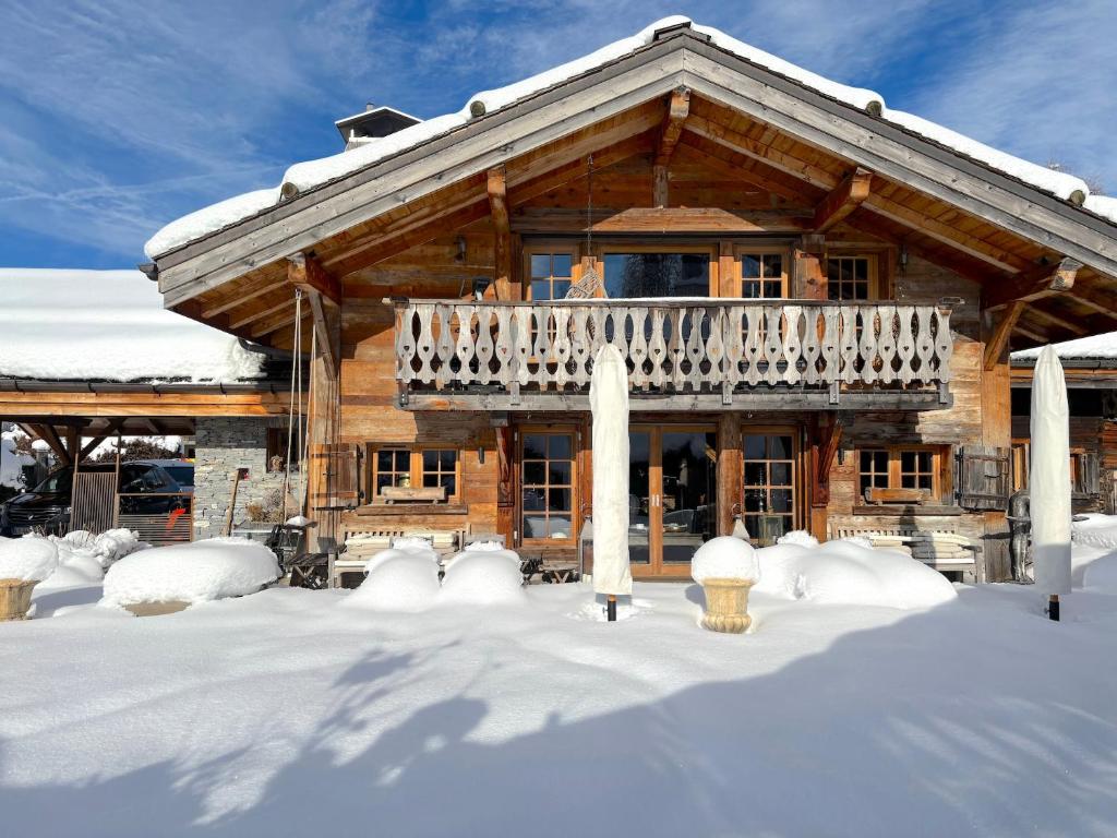 una baita di tronchi con balcone nella neve di Chalet Hermine a Megève