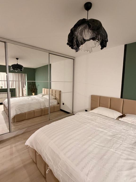 um quarto com duas camas e um espelho grande em Sage Studio em Drobeta-Turnu Severin