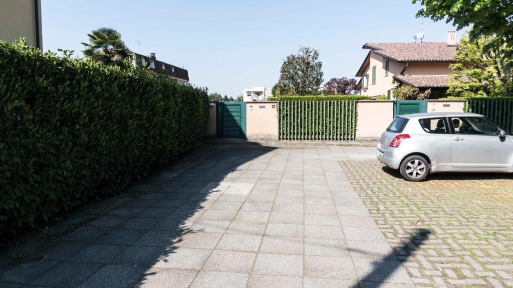 Ein weißes Auto parkte in einer Einfahrt neben einer Hecke. in der Unterkunft BeB Gallozzo in Cesate