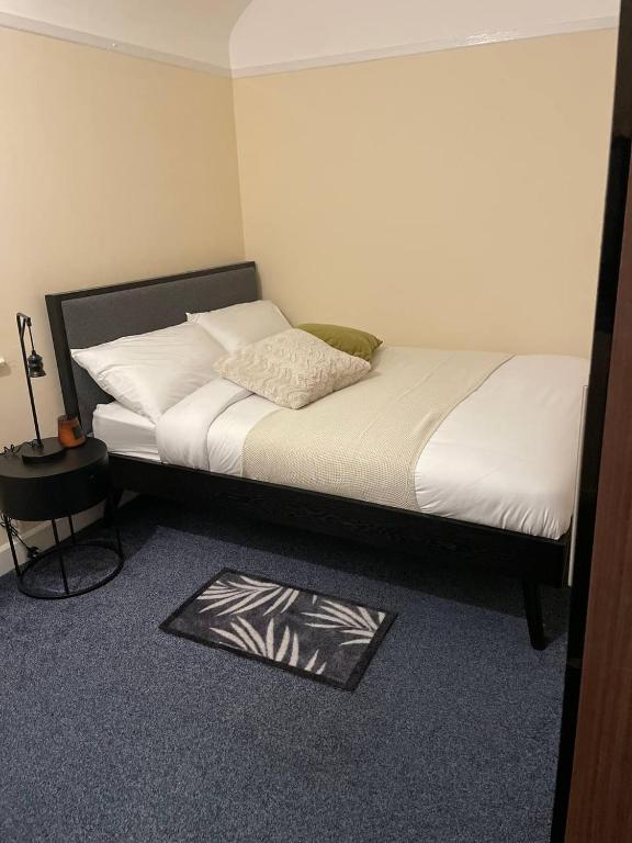 ein Bett in einem Zimmer mit einer Matte auf dem Boden in der Unterkunft GlowHavenStay in Manchester