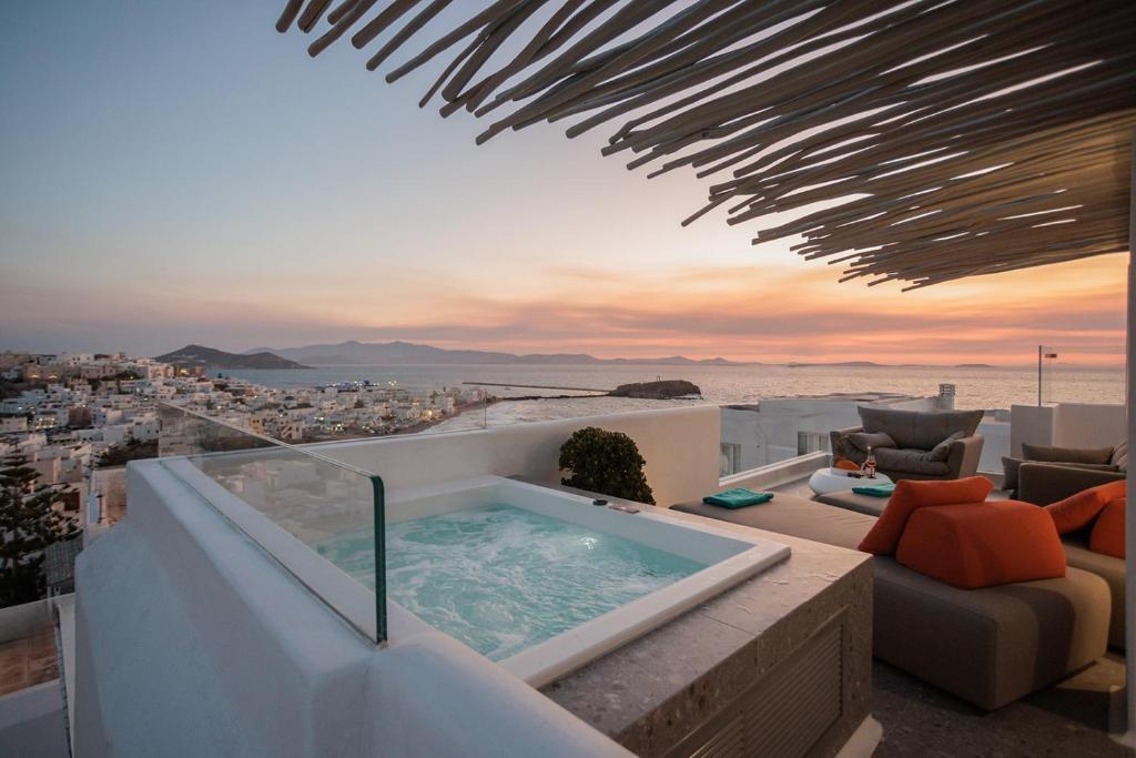 a hot tub on a balcony with a view of the city at HIGH END Unique 270 degree aerial sea view suite in Naxos Chora