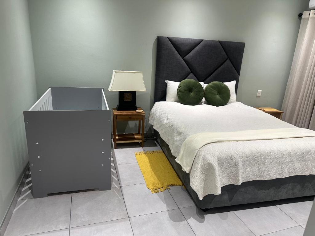 温特和克Little Haven Conerstone cottage的卧室里有一张大床，床铺上铺着绿色枕头