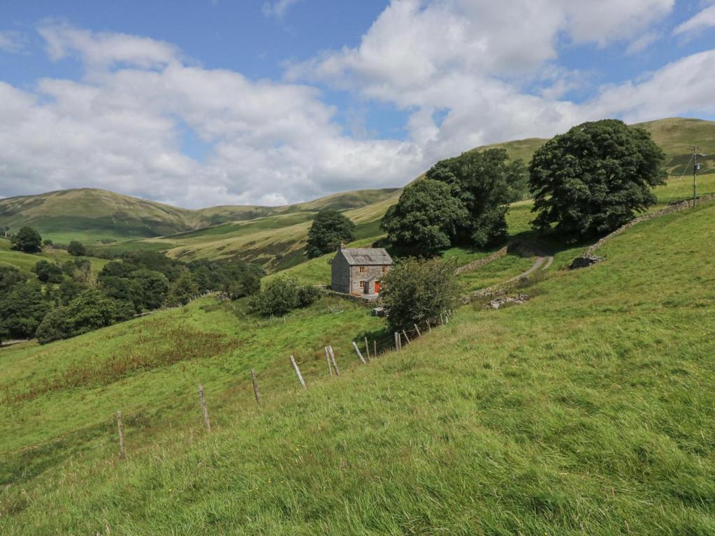 an old house on a hill in a field at Howgill Head in Kendal