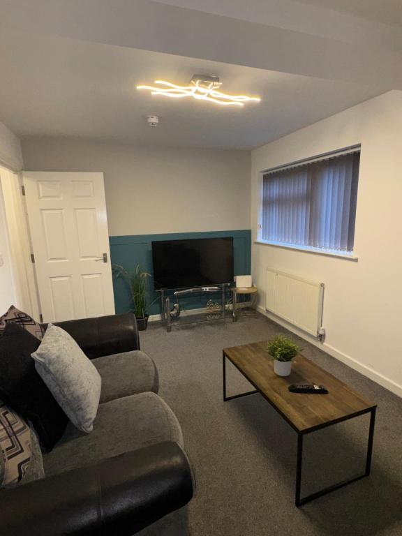 a living room with a couch and a television at Coastal Retreat - Skegness in Skegness