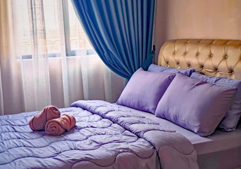 a child is laying on a bed in front of a window at NonaStudio Myra Park Nilai 3 in Nilai