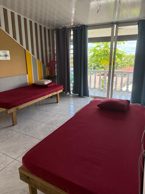 Un dormitorio con una cama y un banco y una ventana. en Dortoir 1, en Faaa