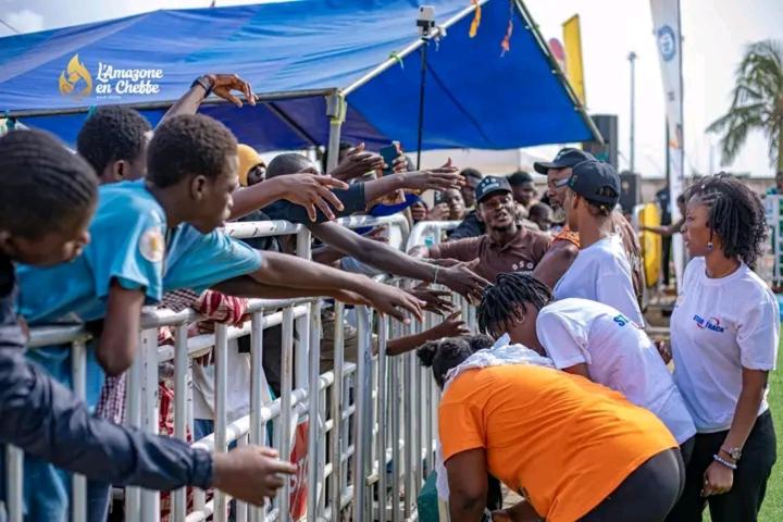 Un grupo de personas intenta alcanzar una valla. en ilikers, en Cotonou