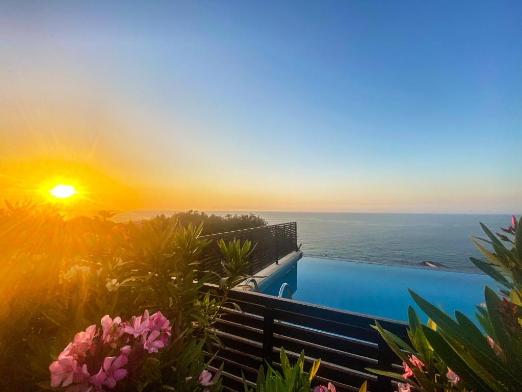 a swimming pool with a view of the ocean at sunset at Villa Sea Cliff 1 in Kyrenia