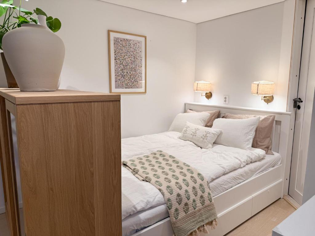 Un dormitorio pequeño con una cama con sábanas blancas. en New modern apartment, en Bergen