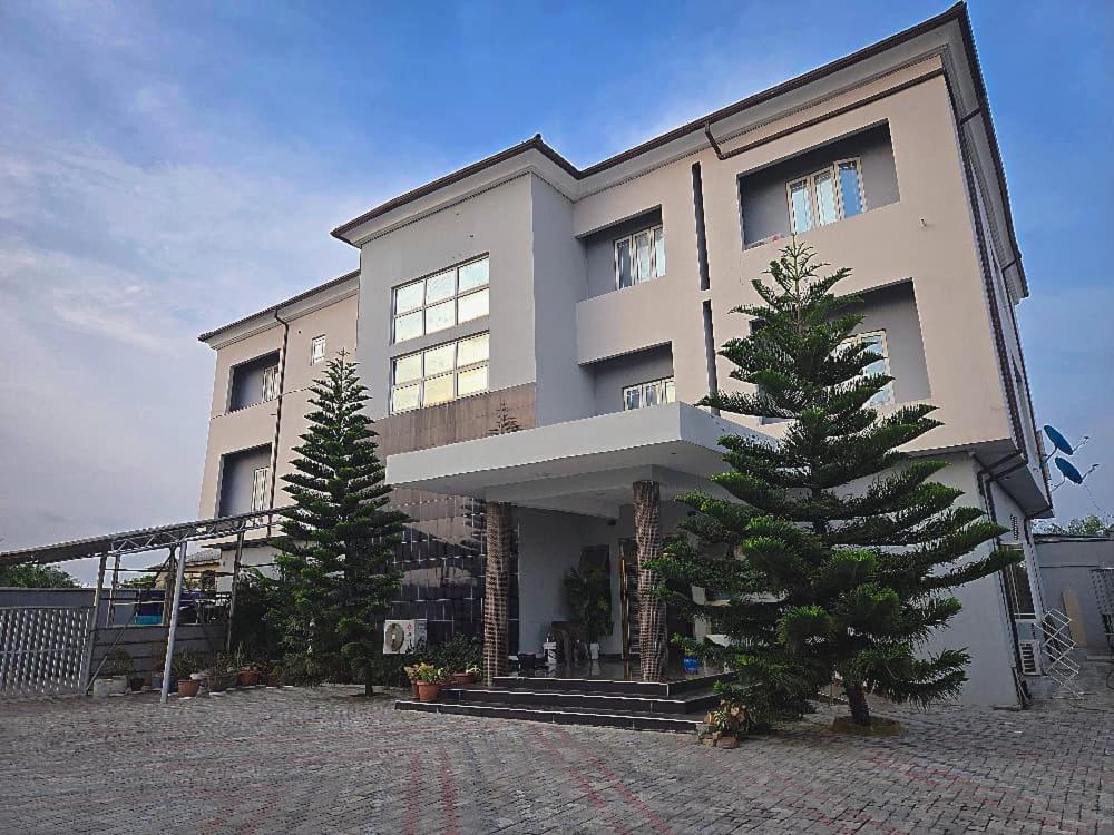 una casa grande con un árbol delante en Merrigold Resorts, en Gbogije