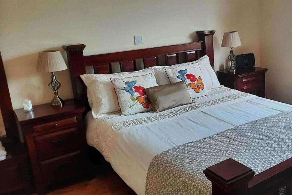 a bedroom with a bed with a wooden headboard and pillows at Tranquil Retreat at Ailt Cottage in Dunfanaghy