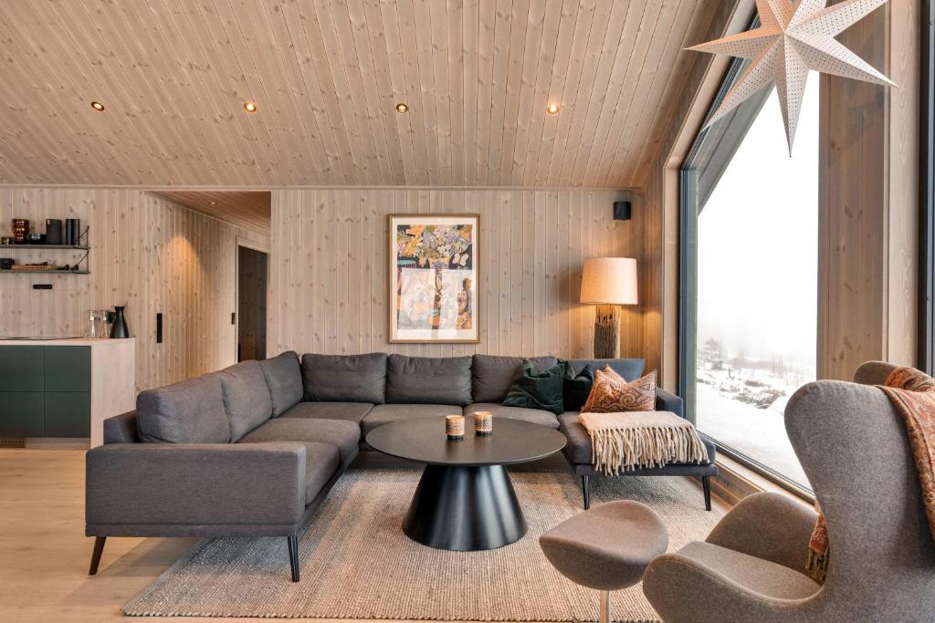 a living room with a couch and a table at Trysil hytteomrade 2041 by Vacation Trysil in Hovi