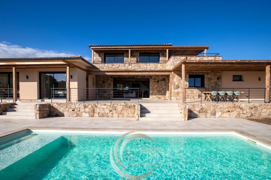 a villa with a swimming pool and a house at Villa Neuve Corse sud avec vue mer et piscine chauffée in Pianottoli-Caldarello