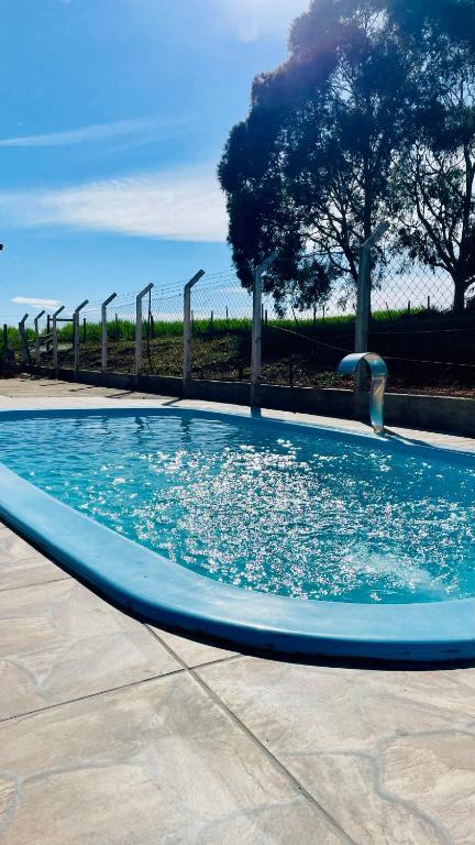 a large blue swimming pool with a wooden fence at Casa de campo in Botucatu