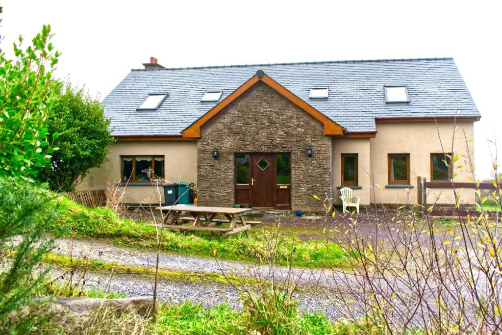 ein Haus mit einem Picknicktisch davor in der Unterkunft West Kerry House Camp in Tralee