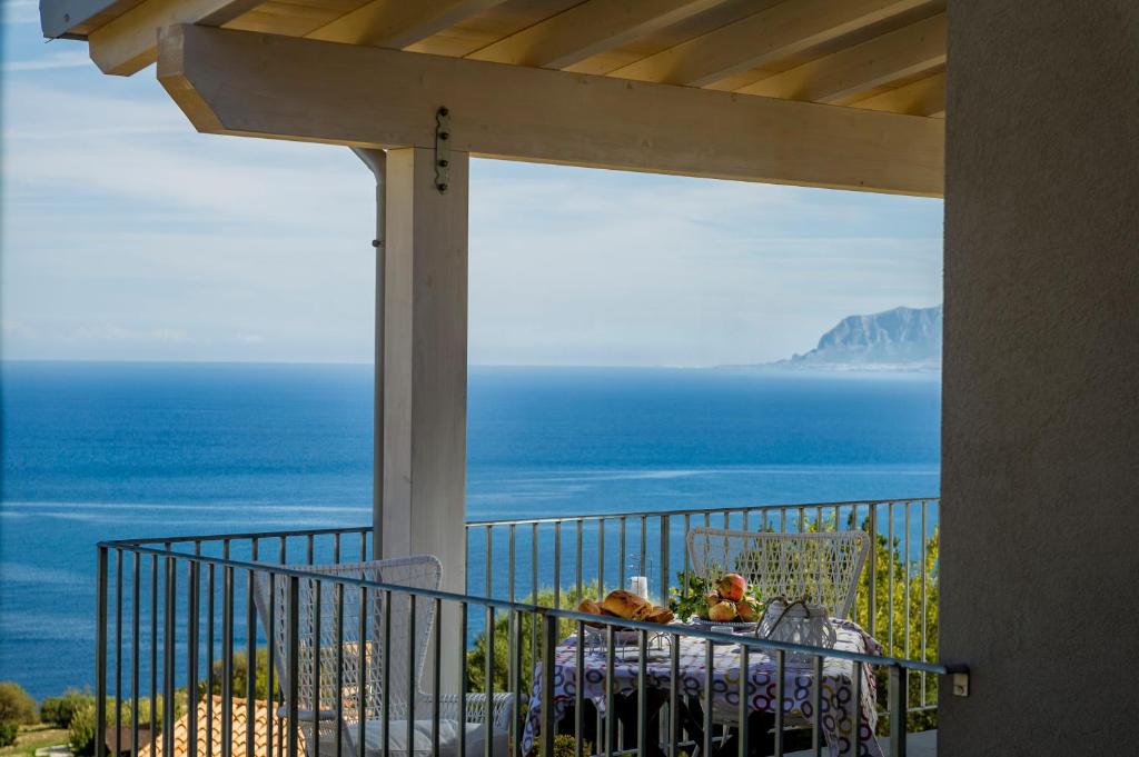 a balcony with a table with a view of the ocean at Villa Rosaria vicino la Riserva dello Zingaro in Scopello