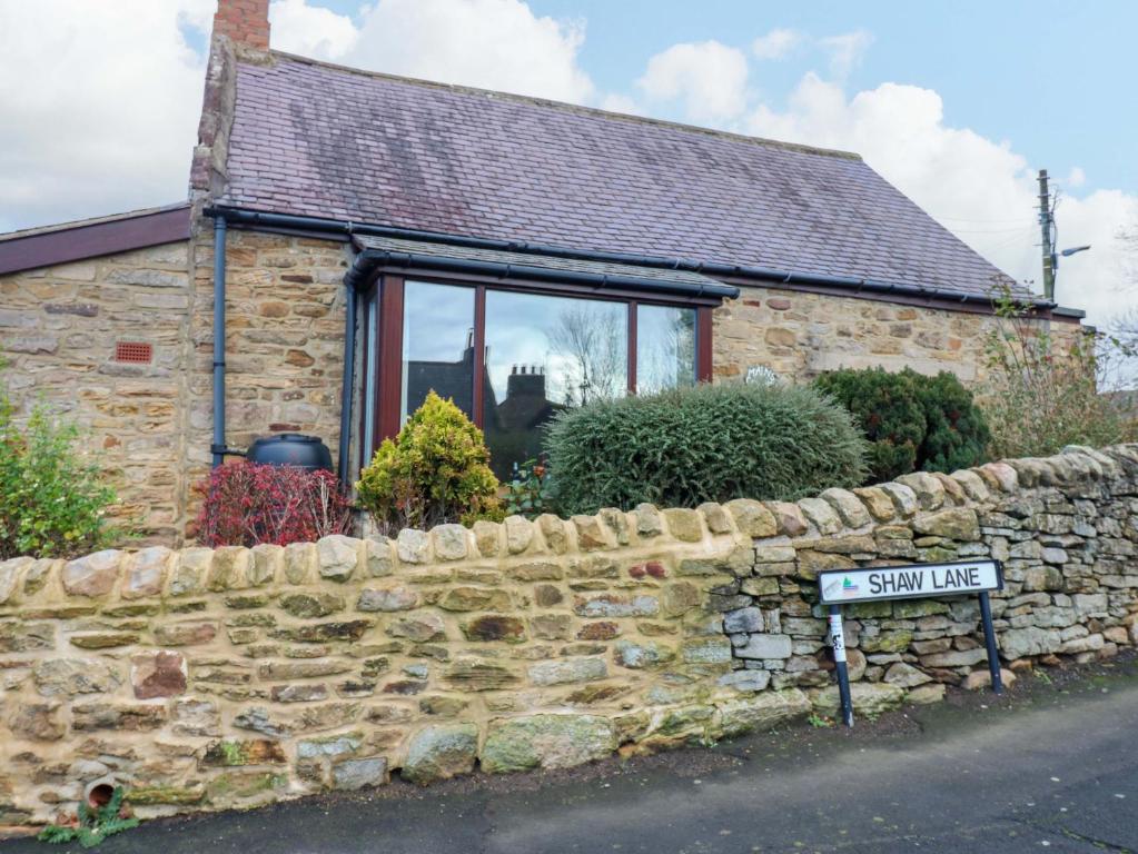 a stone cottage with a street sign in front of it at Mains Cottage in Consett