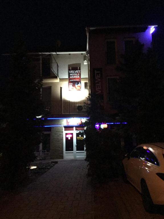 a building at night with a car parked in front at Velvet Motel in Hegyeshalom