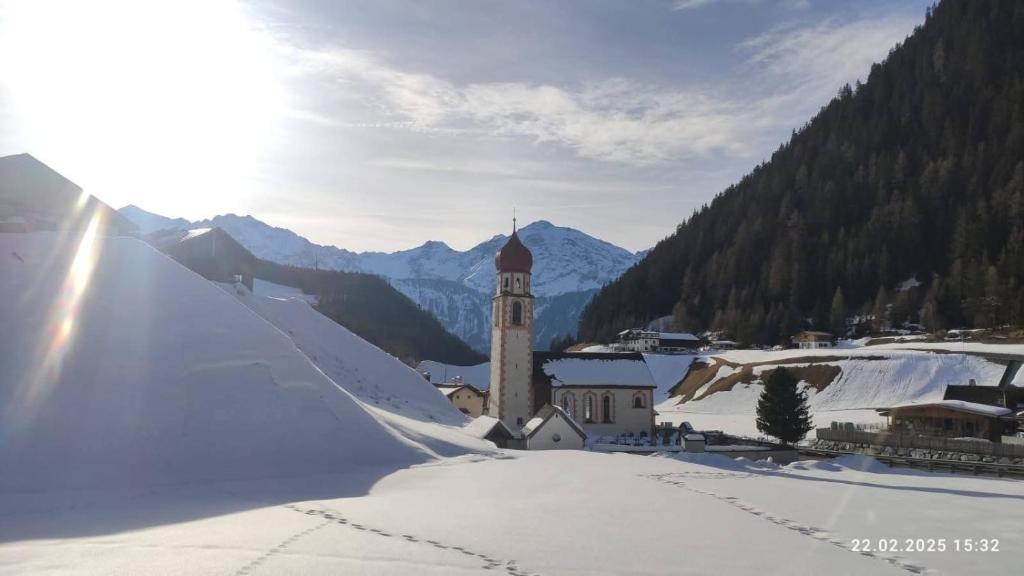 a small town with a clock tower in the snow at Apart Stefan Niederthai in Niederthai