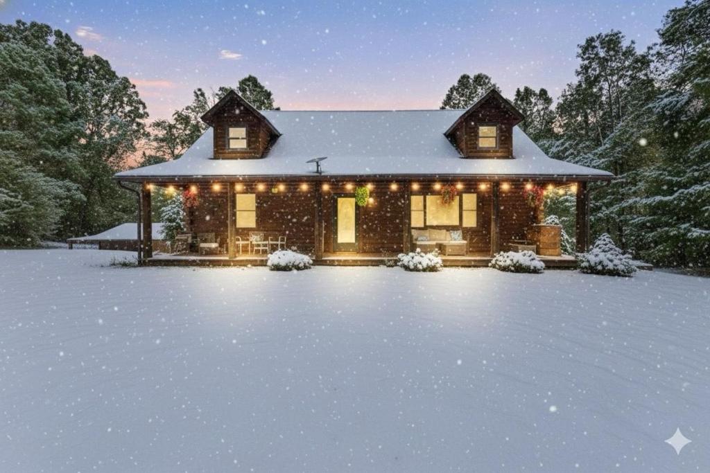 a house covered in snow at night at Lux Spacious Cabin Hot Tub, Indoor Pickleball in Hocking Hills in Logan