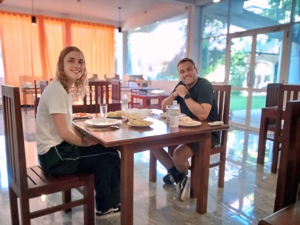 a man and woman sitting at a table in a restaurant at Elephant Orphanage Edge Hotel in Udawalawe