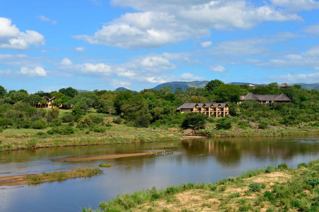 une rivière avec des maisons sur son côté dans l'établissement Pestana Kruger Lodge, à Malelane