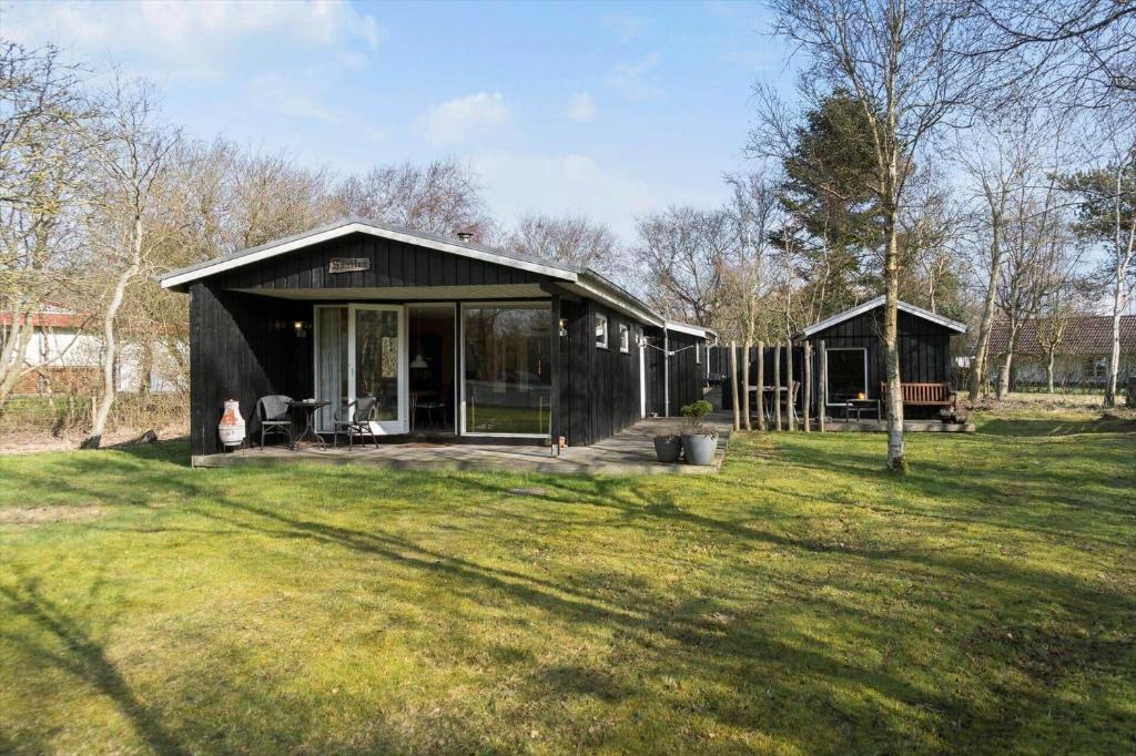 een zwart huis in een veld met een grasveld bij LF407-Hurup-Thy-Nattergalevej-7 in Sønder Ydby