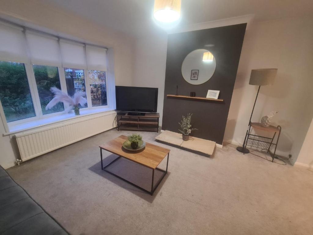 a living room with a flat screen tv and a table at Marsden Modern 3 Bed in South Shields
