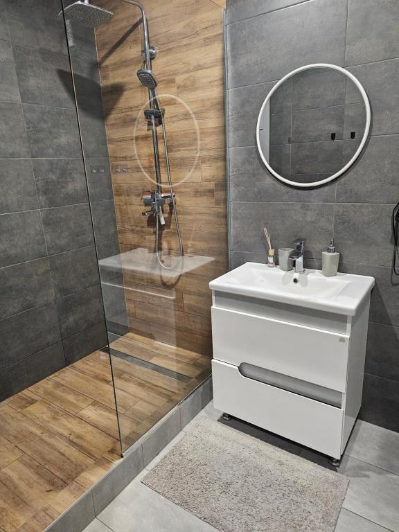 a bathroom with a white sink and a shower at Сучасна квартира в новобудові біля луцького кільця in Rivne