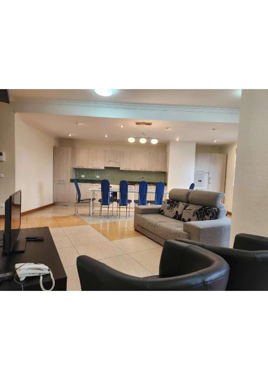 亚的斯亚贝巴Kora Hotel Suites的客厅里有一张沙发、一张桌子和几把椅子。