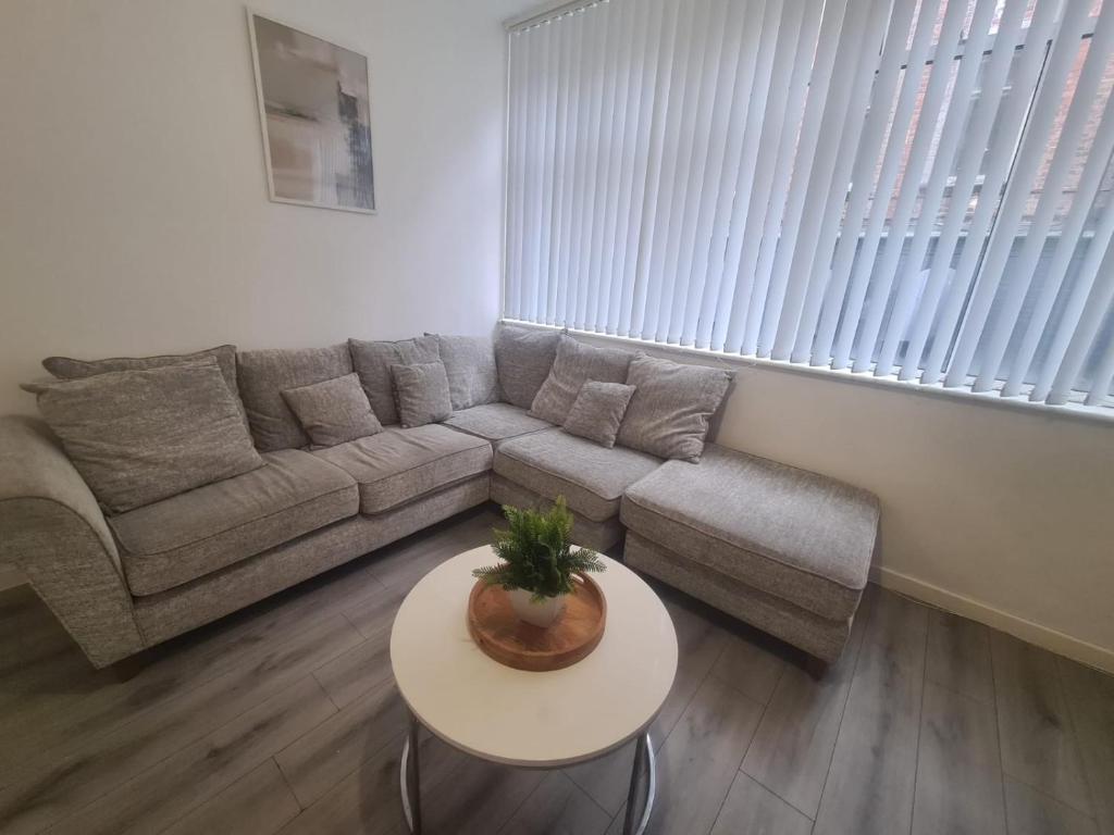 een woonkamer met een bank en een tafel bij Pudding Chare Apartments in Newcastle upon Tyne
