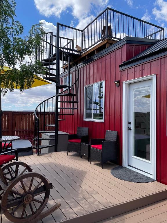 a red building with a staircase and a patio at Zion Tiny Home Rooftop View Deck & Hot Tub in Apple Valley