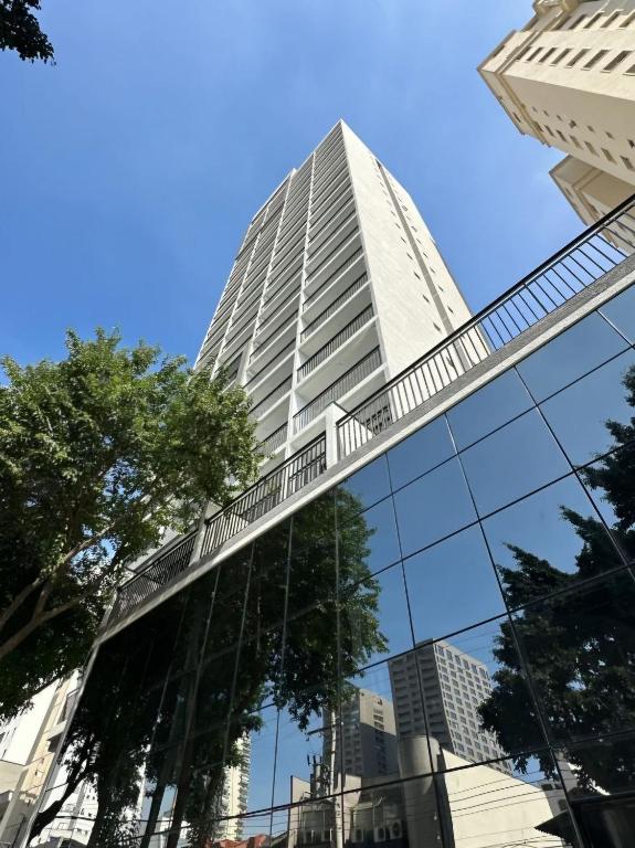 a tall building with its reflection in the windows at Apartamento com Piscina no Rooftop in São Paulo