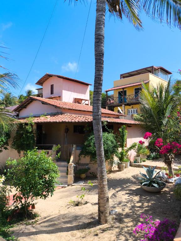 a house with a palm tree in front of it at Casa Mari Suites in Canoa Quebrada