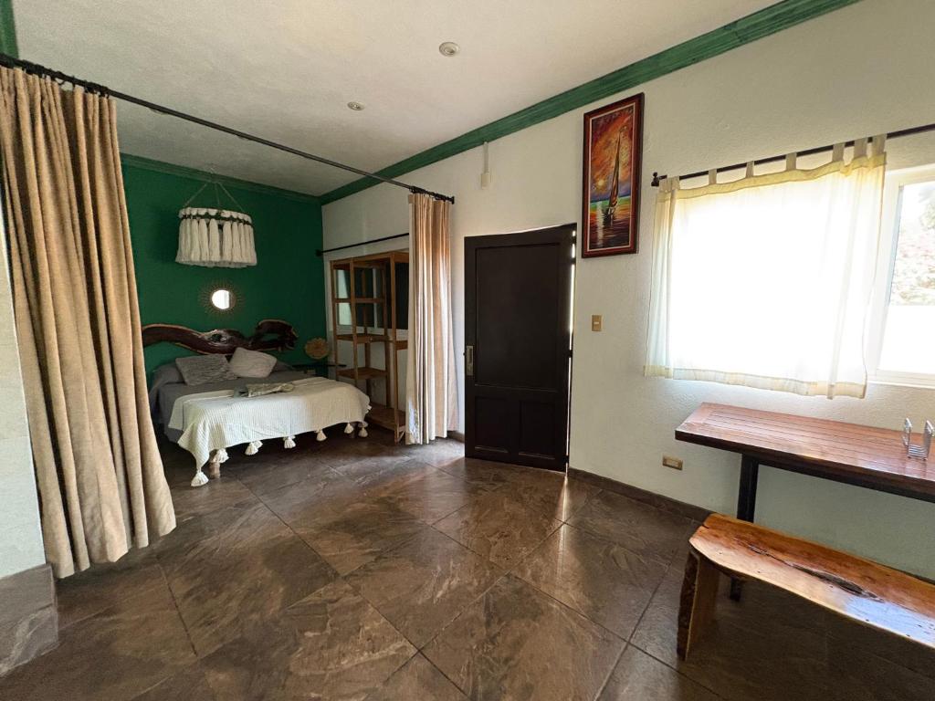 a room with a bed and green walls and a window at Boho luz terrace in San Miguel de Allende