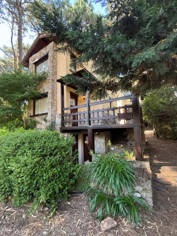 a house with a balcony on the side of it at Ayrampo in Mar de las Pampas