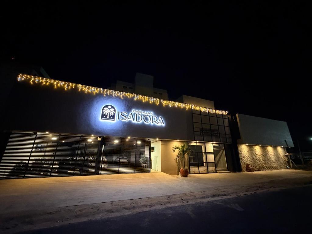 a building with a sign on the side of it at night at Isadora Pousada in Salinópolis