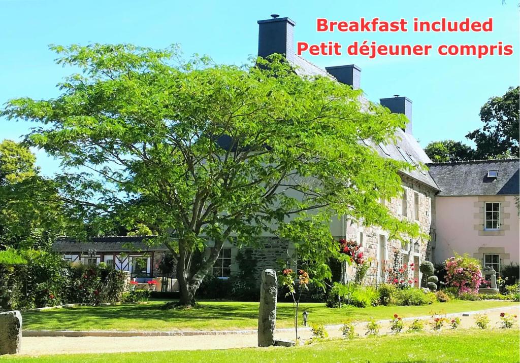 YviasKergroaz Maner Classé 5 épis Table d'Hôtes Manoir dans parc arboré, spa en plein air Bornes véhicules électriques Petit déjeuner inclus的房子前面的一棵树上写着“含早餐”的字样，petainer投诉