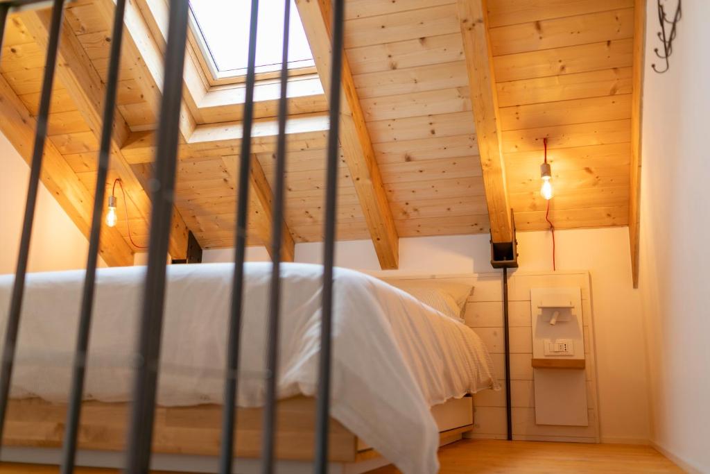 una cama en una habitación con techo de madera en La casa tra gli ulivi, en Génova