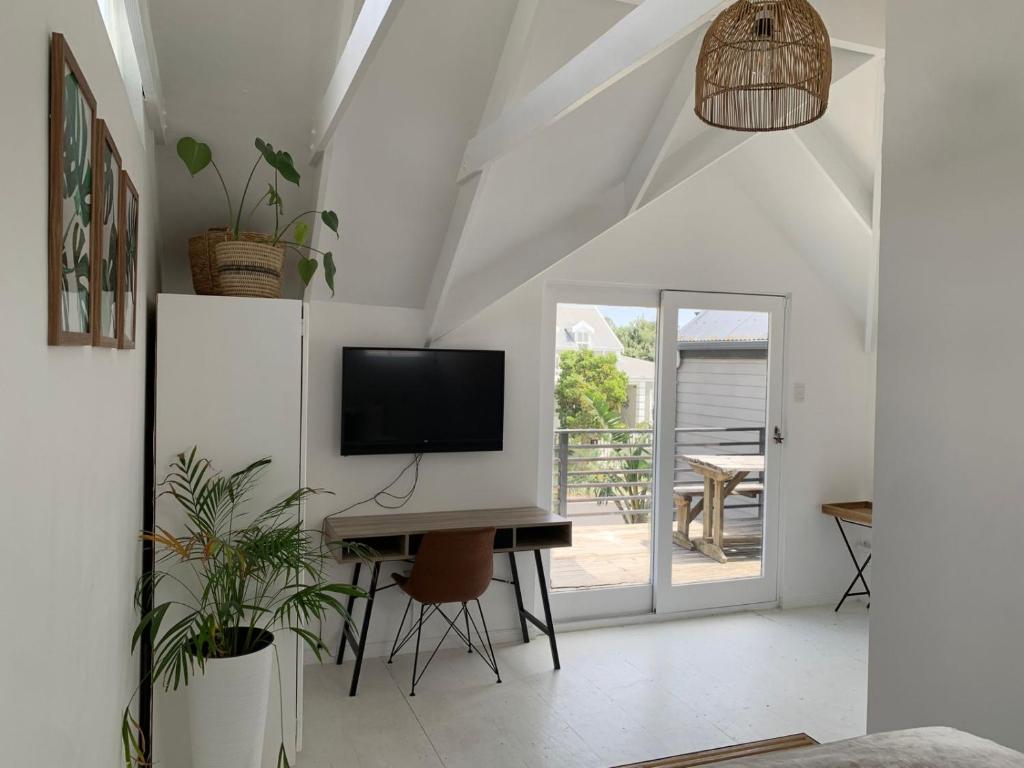 a living room with a tv and a table with a desk at Kommetjie's Gift - Peaceful & Private Escape in Imhoffʼs Gift