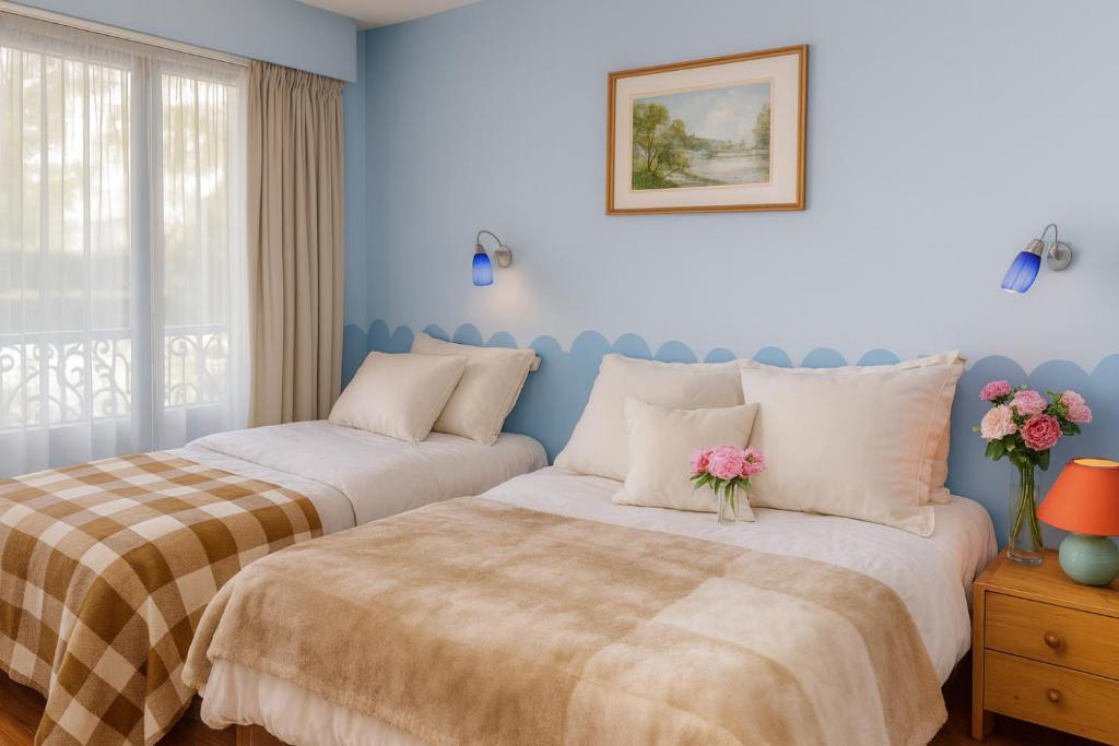 two beds in a bedroom with blue walls at Appartement Premium 100 m2 avec Jardin Privé Plage et Centre à 400 m in Deauville