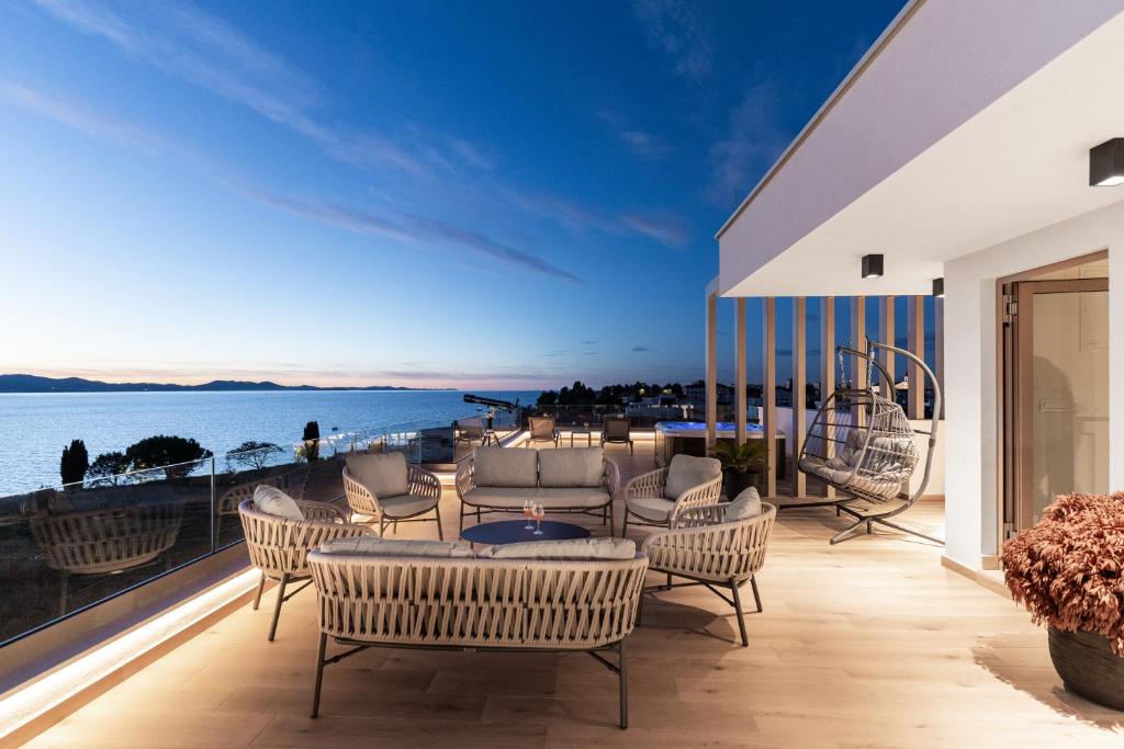 a balcony with chairs and a view of the water at Villa Mare Zadar in Zadar