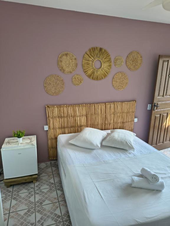 een slaapkamer met een bed met twee handdoeken erop bij Pousada Guarda do Embaú in Guarda do Embaú