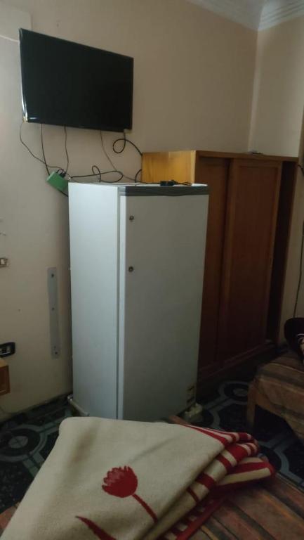 卢克索New mostafa hotel的房间里有一台白色冰箱，冰箱顶部有一台电视机