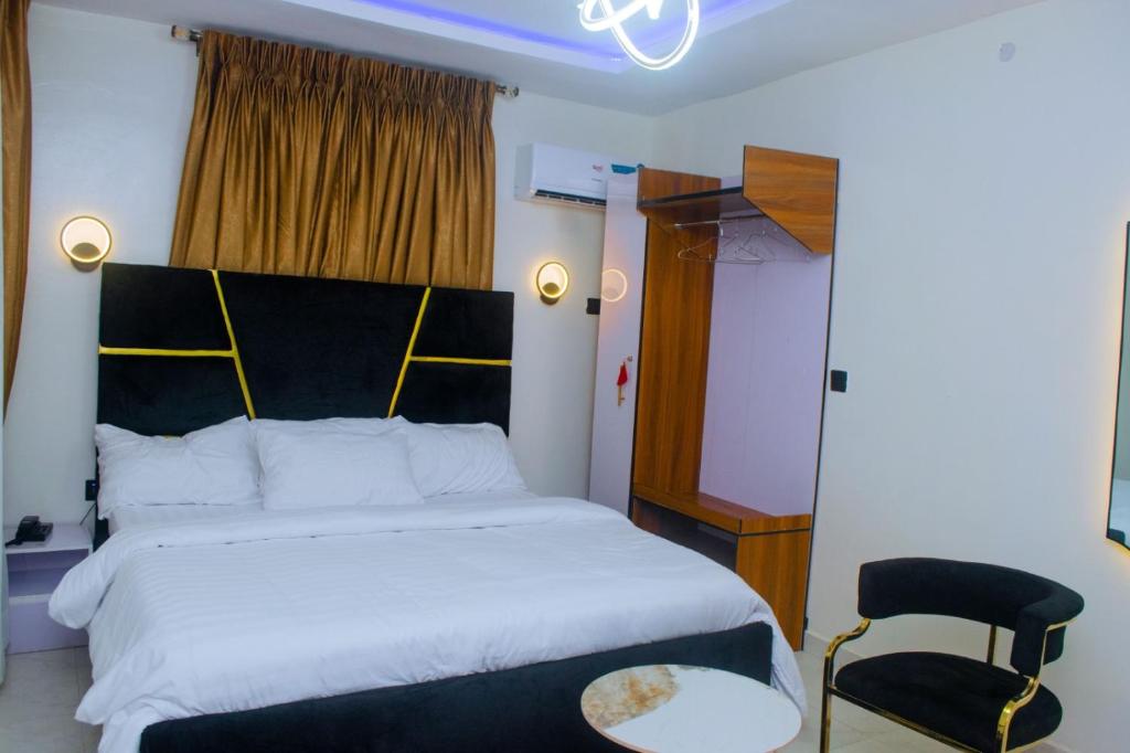 a bedroom with a large bed and a chair at Gpark Luxury Homes And Apartments in Sagamu