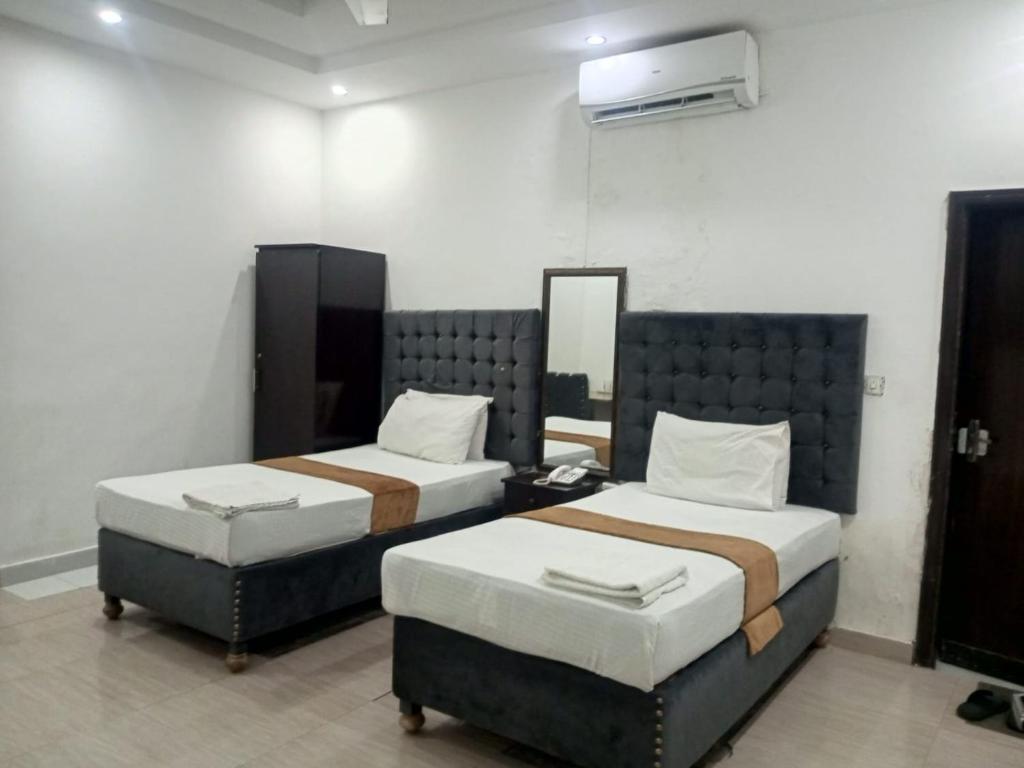 a room with two beds and a mirror at Hotel Tulip INN in Lahore