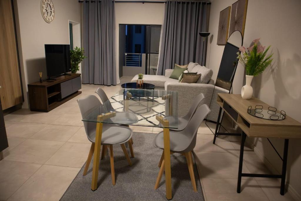 Serene Retreat في ميدراند: غرفة معيشة مع طاولة وكراسي زجاجية